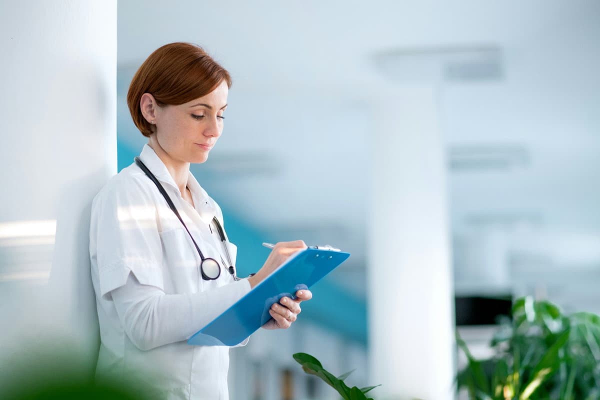 A physician writing in a patient record.