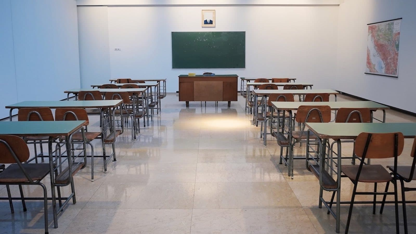 An empty classroom: rows of desks facing a chalkboard.