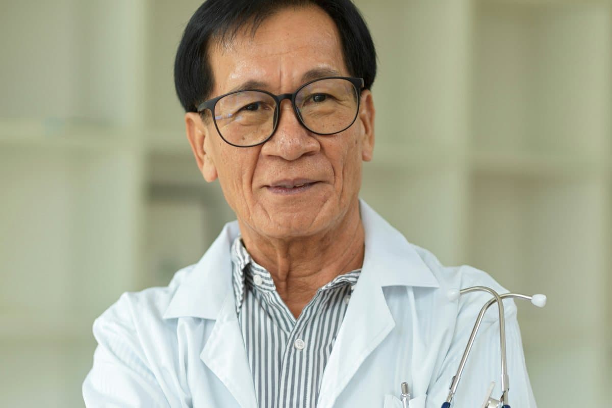 A senior physician in a hospital corridor.